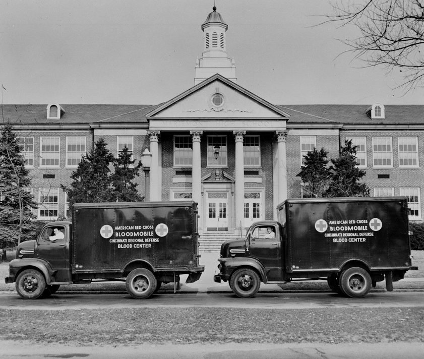 Two blood mobiles in front of a building circa 1940s