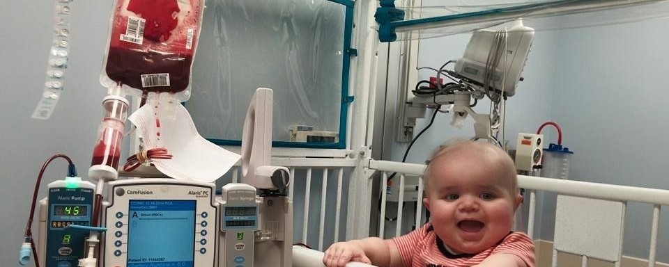 Baby Ryan Dennis receiving a blood transfusion in a hospital crib