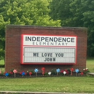 School sign that says "we love you John"