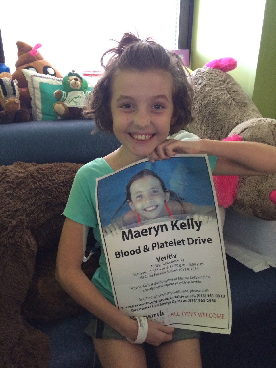 Maeryn Kelly holding a poster for a blood drive in her honor