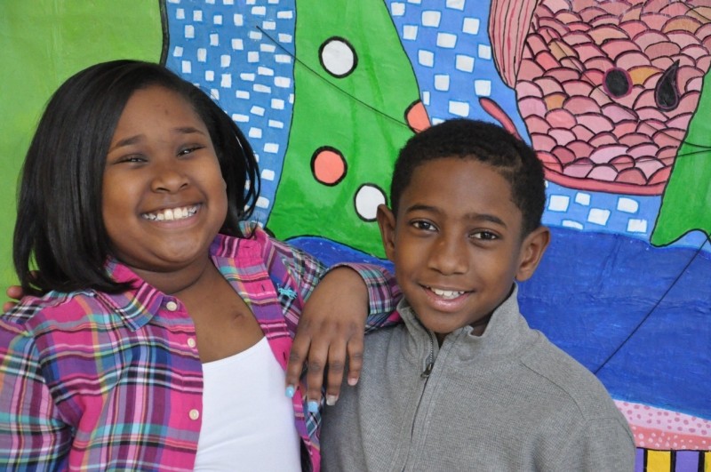 Taryn and King Walker smiling in front of a colorful mural